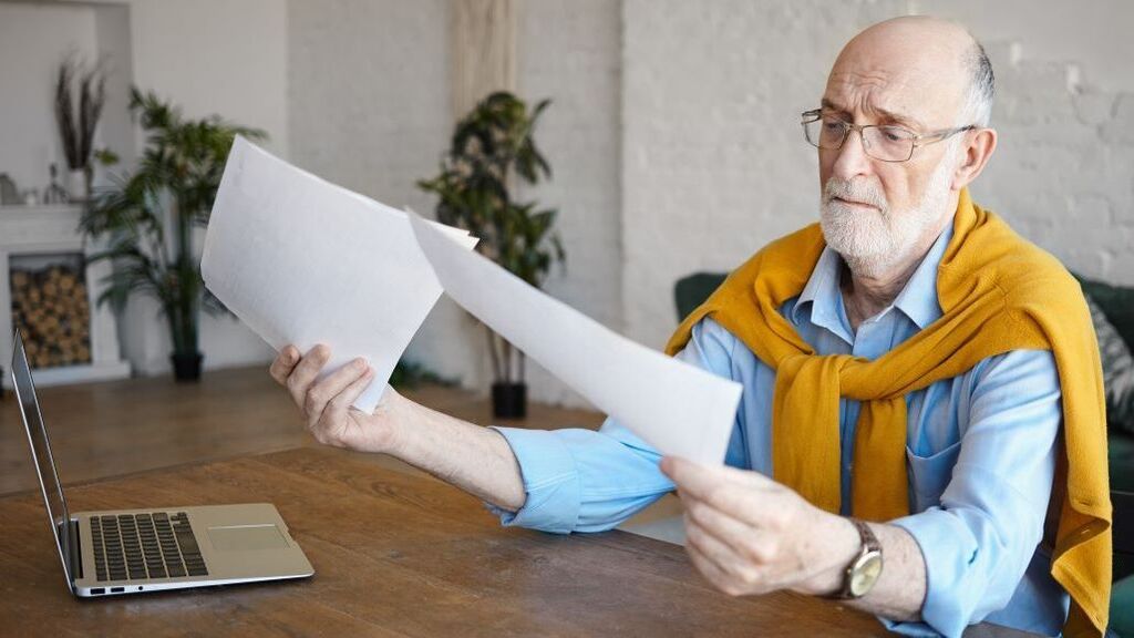 Man in his 60s working at his computer, building an online income after 50 using his skills and experience.